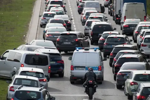 Korki na drodze ekspresowej. Policja próbuje opanować chaos, a motocyklista przeciska się między samochodami.