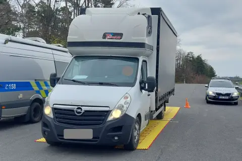 Ciężarówka na żółtej macie kontrolnej, obok radiowóz policji. Kontrola drogowa w Czechach, możliwe mandaty.