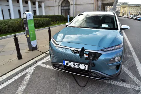 Niebieski Hyundai Kona ładuje się na stacji. To przyszłość, gdy skończy się produkcja aut spalinowych.