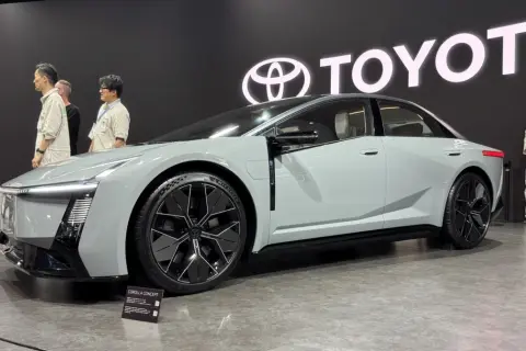 Nowoczesna Toyota Corolla Concept, zapowiedź przyszłych generacji, prezentowana na tle logo Toyota.