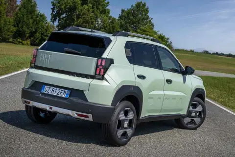 Jasnozielony Fiat Panda, jeden z najlepszych hatchbacków, na tle zielonych wzgórz.