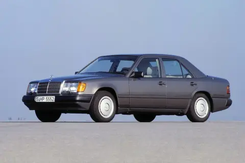 Szary Mercedes W124, symbol najbardziej niezawodnych samochodów, stoi na płaskiej nawierzchni.