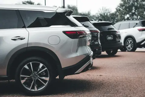 Rzędy lśniących SUV-ów, w tym srebrny model z silnikiem wolnossącym, czekają na swoich właścicieli.