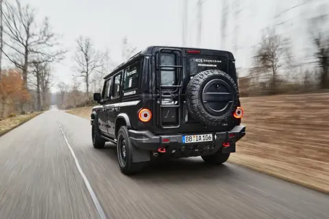 Czarny INEOS Grenadier, jeden z nowych, potężnych **marek samochodów terenowych**, pędzi leśną drogą.