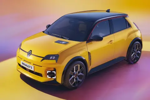 Żółty samochód elektryczny Renault 5 z czarnym dachem i czerwonym akcentem.