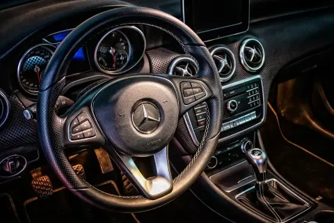 Wnętrze Mercedesa z kierownicą i deską rozdzielczą. Idealne do wynajem samochodu powyżej 150 tys. km.