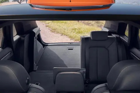 Widok z bagażnika na tylne siedzenia i otwartą klapę. Wnętrze Audi Q3 gotowe na podróż.