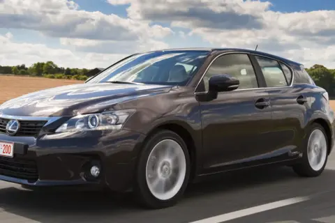 Ciemnobrązowy Lexus CT 200h w ruchu drogowym. Szukasz auta, która hybryda pali najmniej? Ten model to świetny wybór.