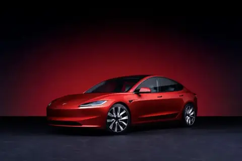 Czerwony Tesla Roadster, choć wygląda jak auto spalinowe, jest elektryczny. Jego futurystyczny design i sportowe linie przyciągają wzrok.