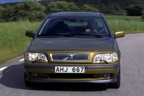 Złoty Volvo S40 jedzie po wiejskiej drodze. Skąd jest to Volvo? Z pewnością z krainy spokoju i zieleni.
