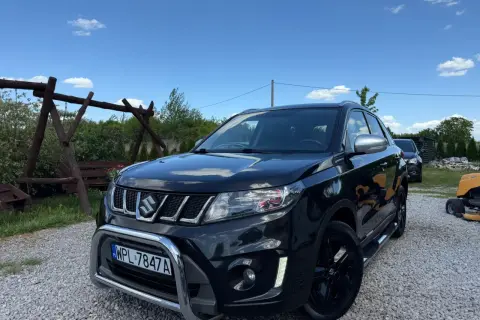 Czarny Suzuki Vitara 1.4 Boosterjet, z chromowanym grillem i zderzakiem, stoi na żwirze. Czyżby awarie?