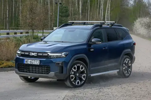 Ciemnoniebieski SUV z bagażnikiem dachowym, idealny na podróże. To najlepsze auto na gaz, gotowe na każdą drogę.