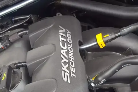 Silnik SKYACTIV TECHNOLOGY, serce oszczędnych silników benzynowych, z widocznymi przewodami i złączkami.
