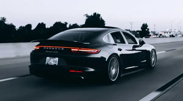 Czarny Porsche Panamera Turbo jedzie autostradą. Tablica rejestracyjna CVC-911. Limit 150 tys. VAT-26.
