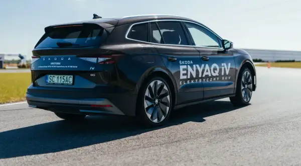 Ciemny Skoda Enyaq iV, jeden z popularnych SUVów, na drodze testowej.