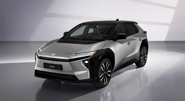Srebrny Toyota bZ4X z czarnym dachem, gotowy na długie podróże. Ten elektryczny SUV oferuje imponujący zasięg.