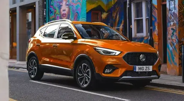 Pomarańczowy MG ZS na tle kolorowego muralu. Czy to marka MG? Tak, to MG!