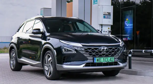 Czarny Hyundai na wodór zaparkowany przy stacji tankowania. Nowoczesny design i ekologiczne paliwo.
