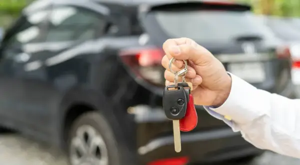 Kluczyki do samochodu po leasingu w dłoni. Nowy właściciel odbiera auto.
