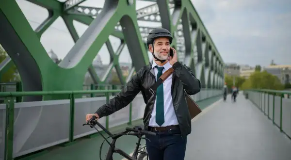Biznesmen na rowerze rozmawia przez telefon, zastanawiając się nad zakupem roweru na firmę a VAT.