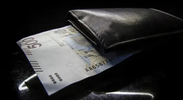 Czarny portfel z banknotem 500 zł. Zastanawiasz się nad opłatami dodatkowymi w leasingu a VAT?