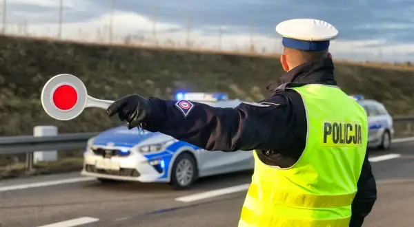 Policjant kieruje ruchem, sygnalizując zatrzymanie. Nowe przepisy drogowe w praktyce.