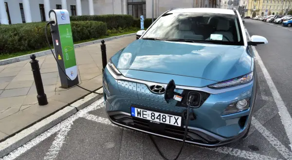 Niebieski Hyundai Kona ładuje się na stacji. To przyszłość, gdy skończy się produkcja aut spalinowych.