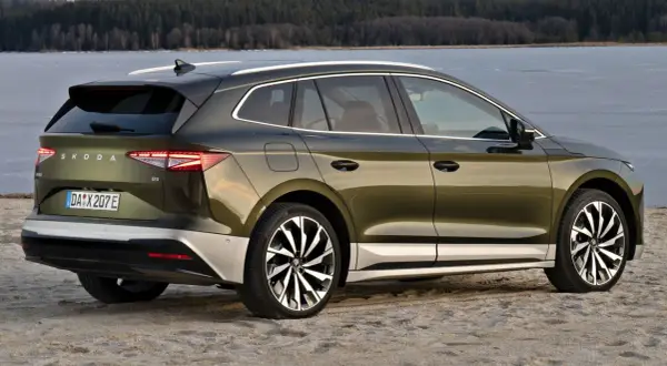 Zielony Skoda Enyaq na plaży, z widokiem na zamarznięte jezioro. Poznaj skoda enyaq wymiary i jego przestronne wnętrze.