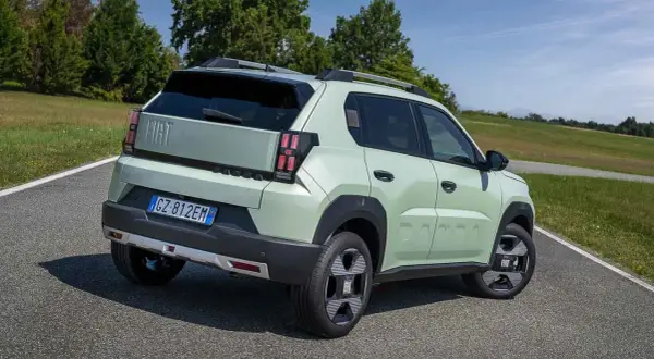Jasnozielony Fiat Panda, jeden z najlepszych hatchbacków, na tle zielonych wzgórz.
