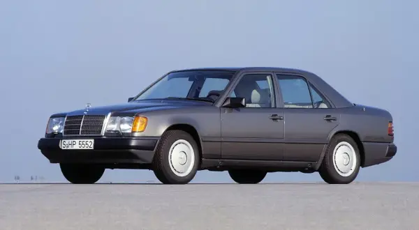 Szary Mercedes W124, symbol najbardziej niezawodnych samochodów, stoi na płaskiej nawierzchni.
