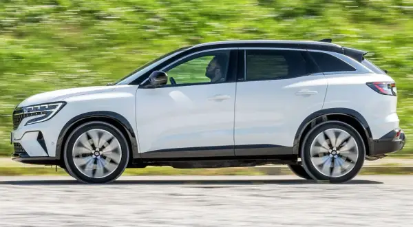 Biały Renault Austral w ruchu, z widocznym kierowcą. Jego dynamiczna sylwetka i nowoczesne linie podkreślają jego wymiary.