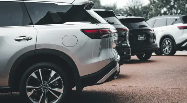 Rzędy lśniących SUV-ów, w tym srebrny model z silnikiem wolnossącym, czekają na swoich właścicieli.