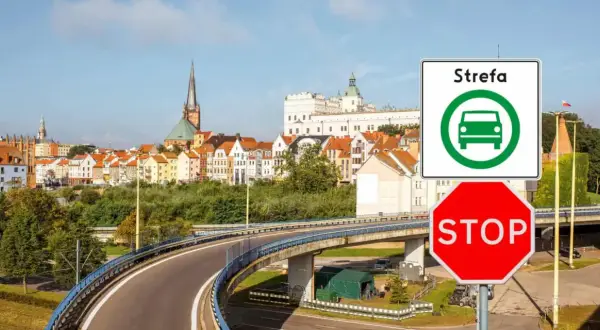 Znak "Strefa czystego transportu Szczecin" i czerwony znak STOP przed panoramą miasta.