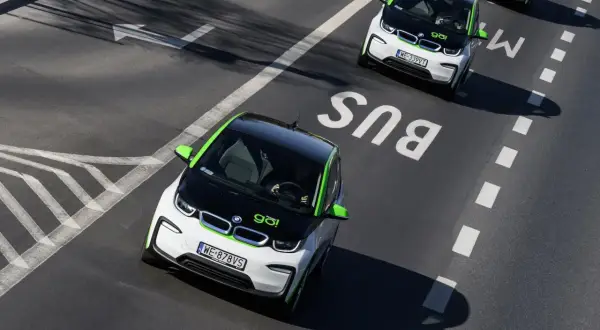 Czy elektryki mogą jeździć buspasem? Dwa biało-zielone BMW i3 jadą buspasem, jeden z nich jest bliżej kamery.