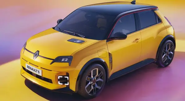 Żółty samochód elektryczny Renault 5 z czarnym dachem i czerwonym akcentem.