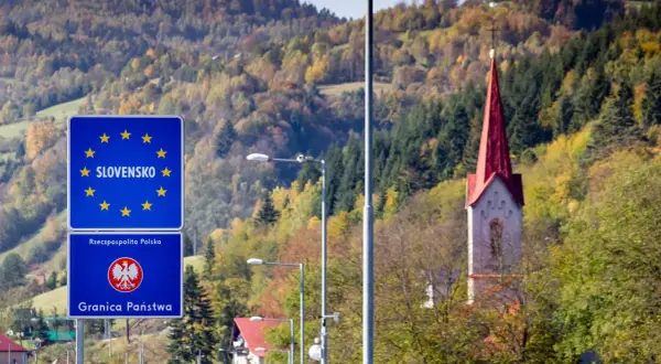 Granica Słowacji i Polski. W tle jesienne wzgórza i wieża kościoła. Fotoradary słowacja pilnują porządku.