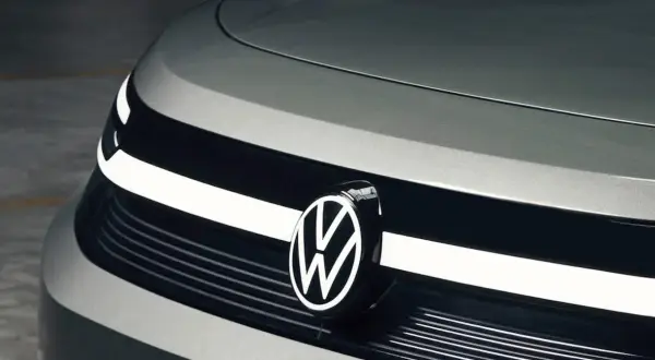 Zbliżenie na przód nowoczesnego samochodu, z widocznym logo Volkswagen. Nowe modele tej marki zachwycają designem.