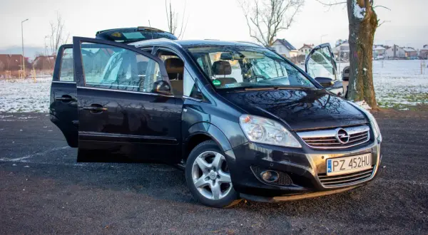 Czarny Opel Zafira B z otwartymi drzwiami, prezentujący różne wersje wyposażenia.