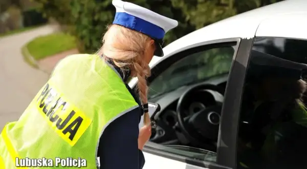 Policjantka w kamizelce odblaskowej rozmawia z kierowcą. Zastanawiasz się, na ile zabierają prawo jazdy za prędkość?