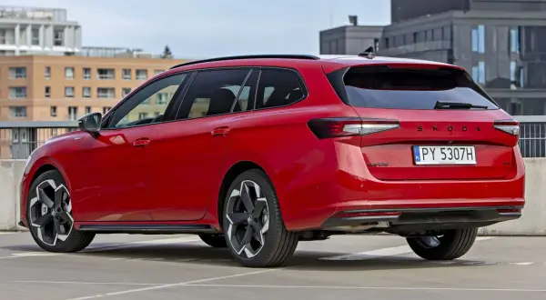 Czerwone, najładniejsze kombi Skoda Superb na parkingu. Eleganckie linie i nowoczesny design.