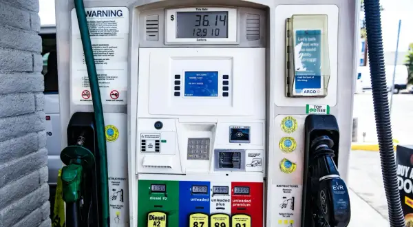 Stacja paliw z dystrybutorem, na którym widać cenę **diesel** do miasta, różne rodzaje paliwa i instrukcje.