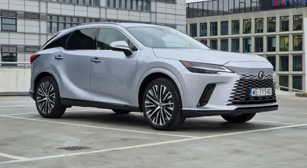 Eleganckie japońskie samochody, jak ten srebrny Lexus, prezentują się nowocześnie na tle biurowców.