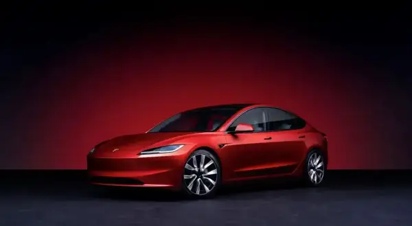 Czerwony Tesla Roadster, choć wygląda jak auto spalinowe, jest elektryczny. Jego futurystyczny design i sportowe linie przyciągają wzrok.