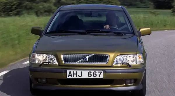 Złoty Volvo S40 jedzie po wiejskiej drodze. Skąd jest to Volvo? Z pewnością z krainy spokoju i zieleni.