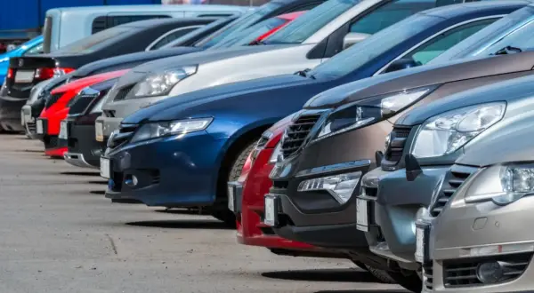 Rząd samochodów na parkingu. Zastanawiasz się, do jakiej kwoty można płacić gotówką za taki pojazd?