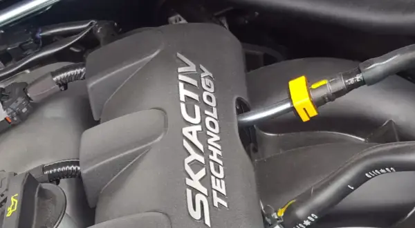 Silnik SKYACTIV TECHNOLOGY, serce oszczędnych silników benzynowych, z widocznymi przewodami i złączkami.