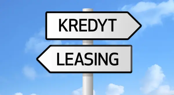 Znak drogowy z napisami "KREDYT" i "LEASING" pod niebieskim niebem z chmurami. Wybór między finansowaniem a zdolnością kredytową.