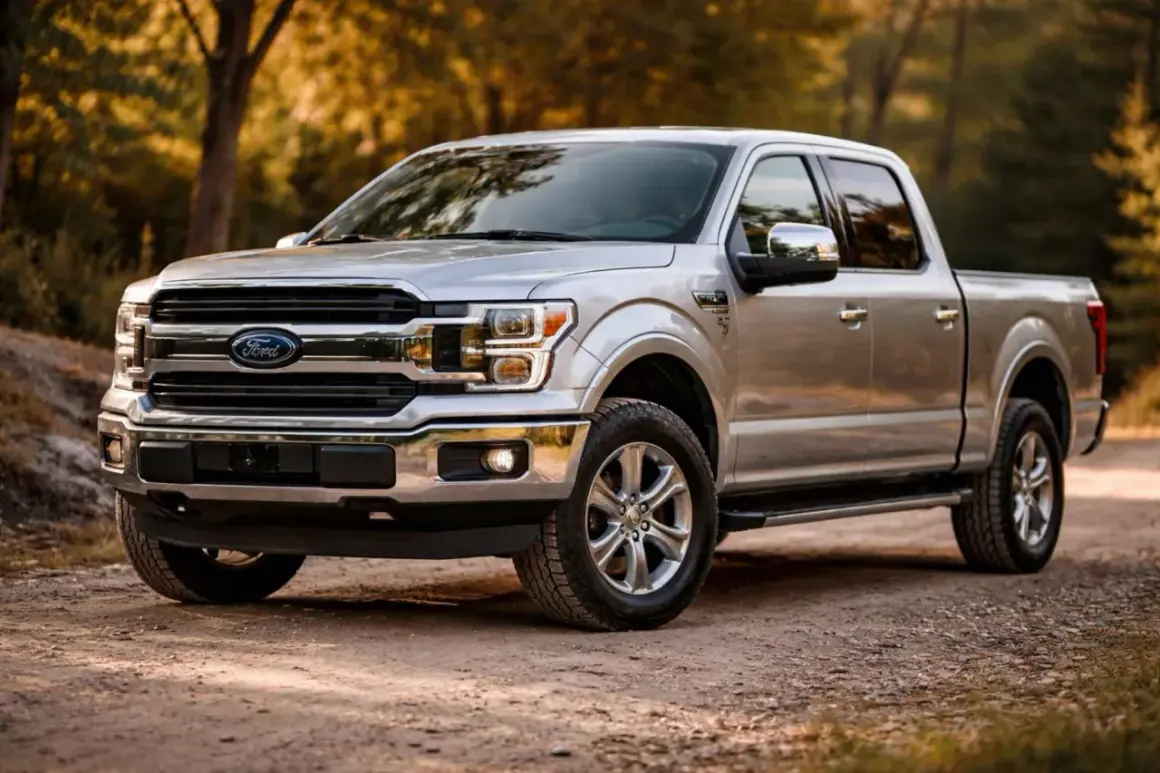 Srebrny pickup amerykański Ford F-150 na leśnej drodze.