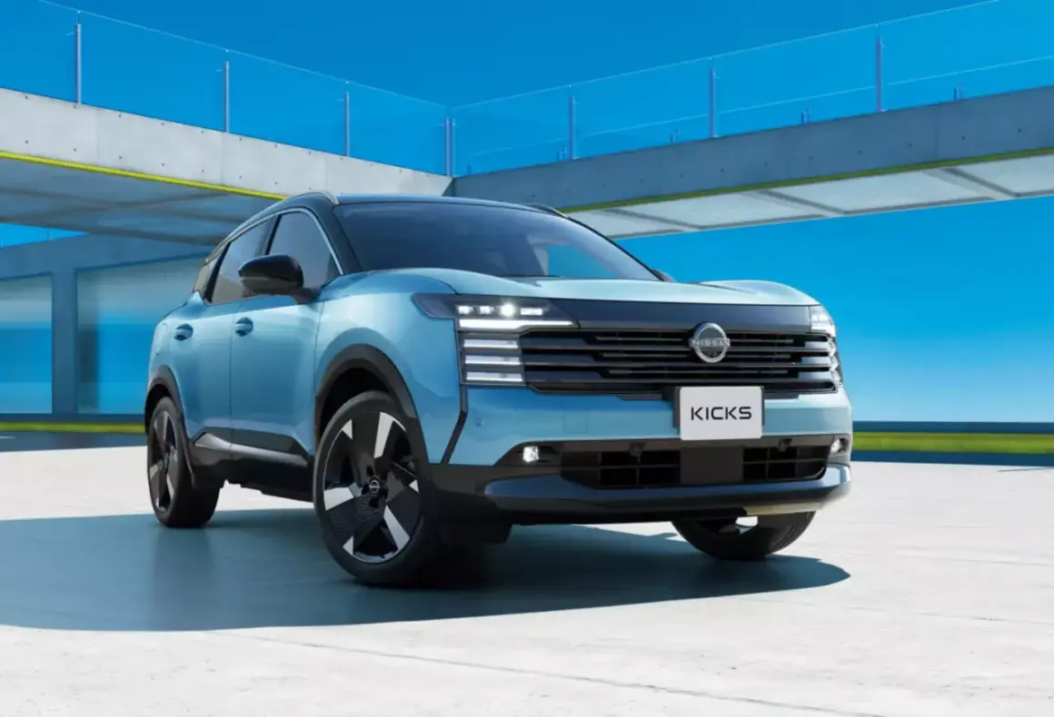 Niebieski Nissan Kicks, segment B, prezentuje się nowocześnie na tle betonowej konstrukcji i błękitnego nieba.