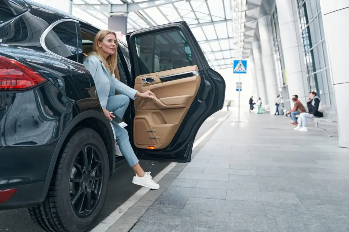 Kobieta wysiada z czarnego SUV-a. Zastanawia się, czy ubezpieczenie samochodu 75 czy 100 w koszty będzie lepsze.